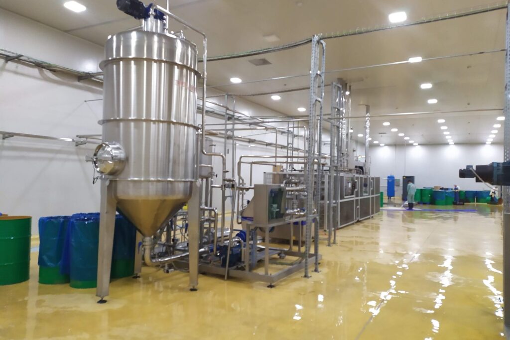 Bồn chứa inox và dãy drum thành phẩm trong nhà máy chế biến trái cây