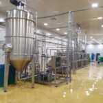Bồn chứa inox và dãy drum thành phẩm trong nhà máy chế biến trái cây
