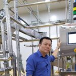 Paul Nguyen bên tủ điều khiển HMI của dây chuyền chế biến trái cây